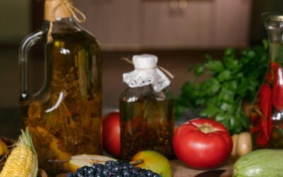 Butelis ypač tyro alyvuogių aliejaus ant medinio stalo virtuvės aplinkoje.