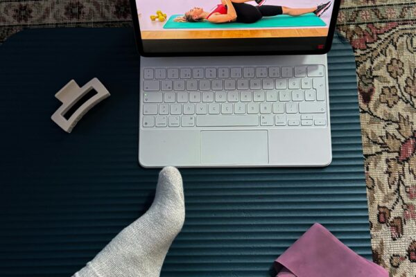 Žmogus atlieka fizinius pratimus namuose naudodamas vandens butelius vietoj svarmenų.