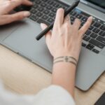 Verslo atstovas analizuojantis svetainės optimizavimo duomenis ir augančius grafikus kompiuterio ekrane.