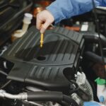 Automobilio variklio alyvos keitimo procesas servise.